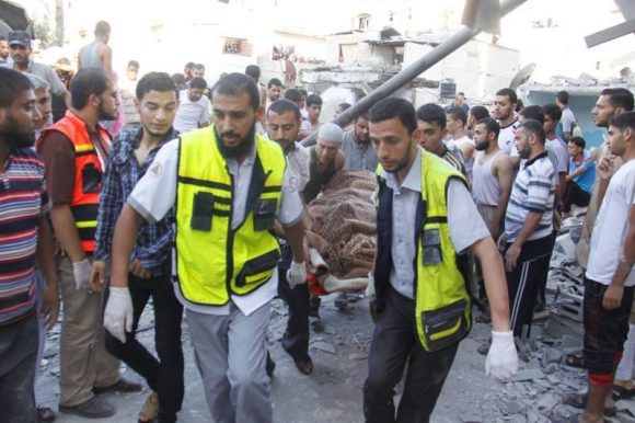 Emergency responders aid Palestinians injured in an Israeli air strike on an UNRWA school in Gaza’s Rafah city, on August 3, 2014. The United Nations said 15 were killed in the blast and a further 25 were injured. (Photo: Palestinian Ministry of Health)